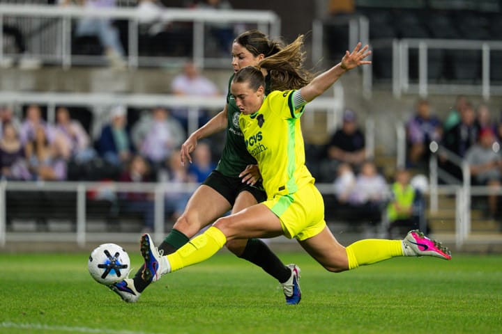 Tara Rudd and Emma Sears both lunge for the ball during the NWSL match between Racing Louisville and the Washington Spirit.